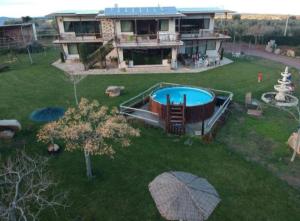 NavahermosaCasa Rural Finca Los Pajaros Montes de Toledo的庭院中带游泳池的房子