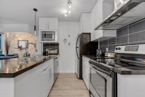 温哥华Gastown Downtown Apartment very central的厨房配有白色橱柜和不锈钢用具