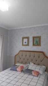 布卢梅瑙Casa linda, luxo e aconchegante的一间卧室配有一张带鲜花的枕头床。