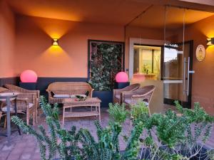 阿西西克拉丹酒店的餐厅前方的庭院配有藤椅和桌子