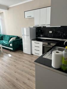地拉那Luxury apartment in the calmest area的厨房配有白色橱柜和绿色沙发