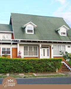 埃雷迪亚Full house, 11BR, 12BA, 10 min from SJO Airport的一座带绿色屋顶的大型白色房屋