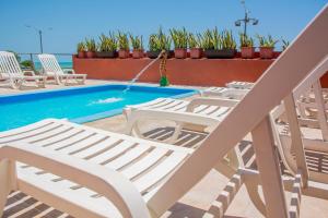 纳塔尔Brisa do Mar Beach Hotel的一组躺椅,位于游泳池旁
