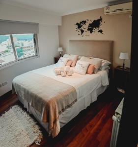 萨尔塔Sarmiento Suites Premium的卧室配有带粉红色枕头的大型白色床