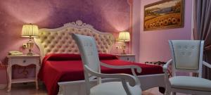 拉戈堡拉托雷酒店的一间卧室配有红色的床和两把椅子