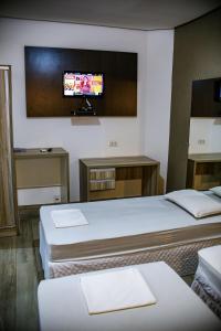 乌贝拉巴Graal Inn Uberaba的酒店客房设有两张床和一台平面电视。