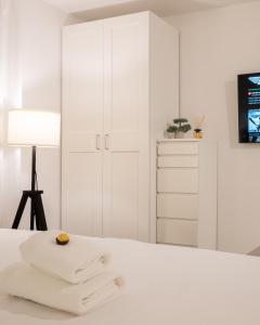 奥西耶克Goldberg Apartments Osijek的白色卧室配有白色橱柜和床上毛巾