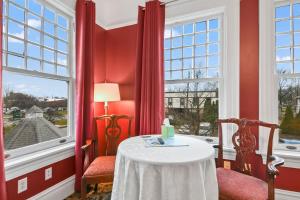 斯普林菲尔德The Pasfield House的红色的房间,配有桌子和两把椅子,并设有一个窗口