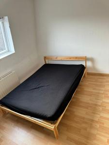 里尔Maison familiale Lille的一张位于带黑色床垫的房间内的床铺