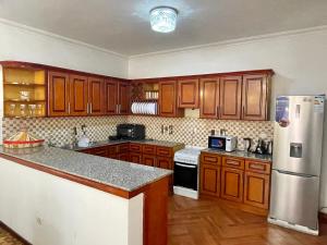 亚的斯亚贝巴METRO Deluxe Specious Home in a Great Neighborhood!!的厨房配有木制橱柜和冰箱。