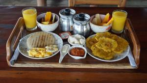 格兰德岛Isla Los Erizos EcoHouse的桌上的食品托盘,配以橙汁