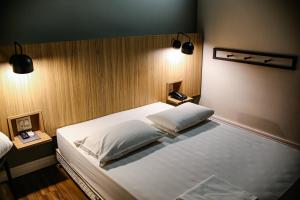 乌贝拉巴Graal Inn Uberaba的一间卧室配有一张大床和两个枕头