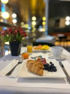 蒙特利尔圣马丁别墅酒店的桌上的白色盘子,上面有羊角面包和水果