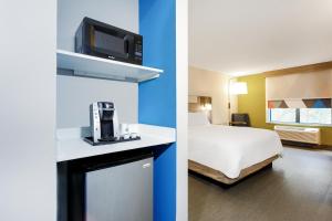 杰克逊维尔Holiday Inn Express Hotel & Suites Jacksonville - Mayport / Beach, an IHG Hotel的一张床位的酒店客房和一张床位的房间的两张照片