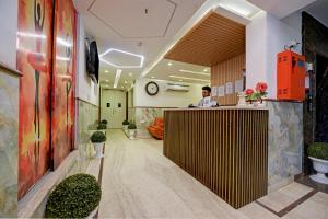 新德里Roseewood Hotel Near Delhi International Airport的站在大厅柜台上的人