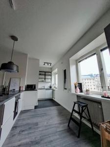 赫尔辛基Renovated 64m2 apartment的一间白色的大厨房,配有柜台和窗户