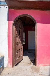 罗萨里托Be steps away from the beach - Downtown Rosarito的粉红色的建筑,设有大型木门