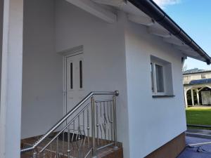 格拉茨Haus in Murfeld Graz的白色的建筑,有门和楼梯