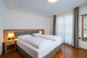 泰塞罗埃里卡酒店的卧室配有一张大白色床和窗户