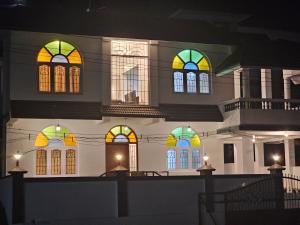 乌提Hestia Chalet 3BHK Villa的一座晚上有彩色彩色玻璃窗的建筑