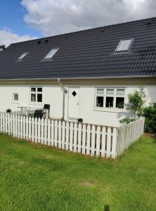 HammelRosengård的白色的房子,有栅栏和黑色屋顶