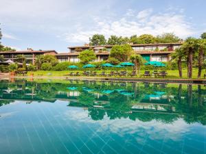卢加诺Park Hotel Principe - Ticino Hotels Group的一个带椅子和遮阳伞的大型水池的度假村