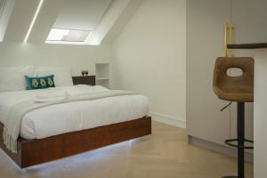 哈罗Luxurious London Studios的一间卧室配有一张床和一把椅子