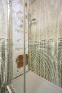 里贝拉Apartamento con jardín en Playa de Corrubedo的浴室里设有玻璃门淋浴