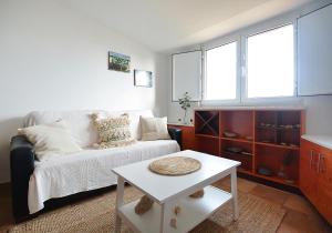 里贝拉Apartamento con jardín en Playa de Corrubedo的客厅配有沙发和桌子