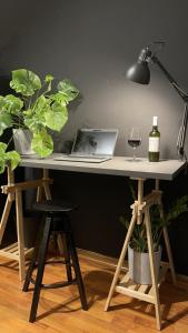 斯皮什新村Urban Zenhouse的一张带笔记本电脑的桌子和一瓶葡萄酒