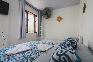 卡波布里奥卡布弗里乌旅馆的一间卧室配有一张带蓝色和白色棉被的床