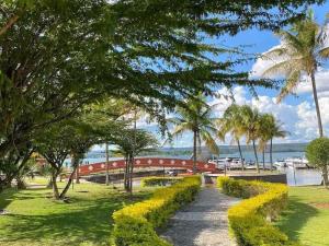巴西利亚Belo Flat Resort Lake Side Beira Lago的公园里的人行道,有桥梁和棕榈树