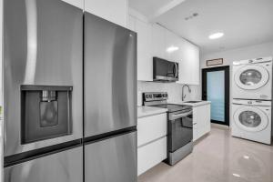 迈阿密Villa Roads Family Home 2 Beds 1 Bath的厨房配有冰箱、洗衣机和烘干机