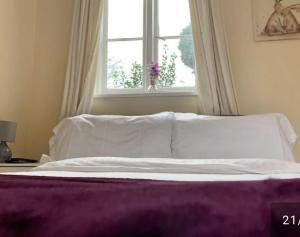 BramleyThe Wheatsheaf的卧室内的一张带白色床单和窗户的床