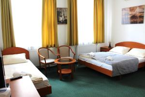 布达佩斯Broadway City Guesthouse的酒店客房,配有两张床和两把椅子