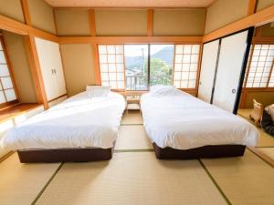 SengokuharaAshigarashimogun - Glamping - Vacation STAY 75753v的配有窗户的客房内的两张床