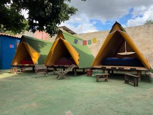 戈亚斯州上帕莱索Ashram no Paraíso.的一组配有长椅和桌子的帐篷