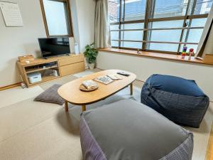 福冈Fukuoka - Apartment - Vacation STAY 00143v的客厅配有桌子和椅子