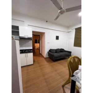 马累Ocean Apartments Hulhumale (Lot 10819)的一间带黑色沙发的客厅和一间厨房