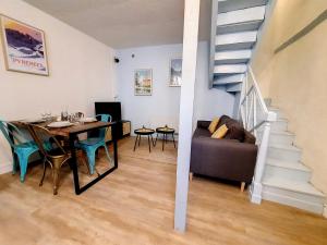塔布Maison La Petite Bleue - Balcon - Wifi Fibre - Menage inclus的用餐室以及带桌子和楼梯的客厅。