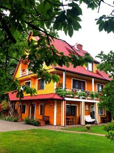 苏普拉希尔pokoje wypoczynkowe "Róża"的一座大型橙色房子,设有红色屋顶