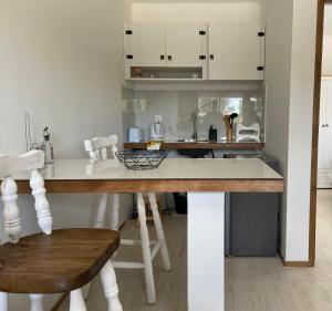 FloridaLa Mia Casa的厨房配有白色橱柜和木桌