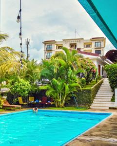 马那瓜Los Vados Hotel的一个人在房子前的游泳池游泳