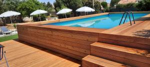 冯塔尼比安奇Residence Cuba alloggi per turismo的一个带遮阳伞的木甲板上的游泳池