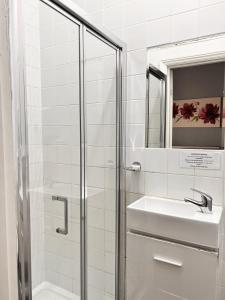 滨海韦斯顿The Grove的带淋浴、盥洗盆和镜子的浴室