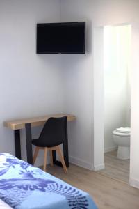 Couhé-VeracRELAIS 375的卧室配有一张桌子,墙上配有电视