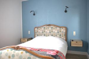 Couhé-VeracRELAIS 375的一间卧室配有一张蓝色墙壁的床