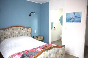 Couhé-VeracRELAIS 375的一间卧室设有一张床和蓝色的墙壁