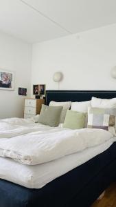 哥本哈根ApartmentInCopenhagen Apartment 1596的一张配有白色床单和绿色枕头的大床