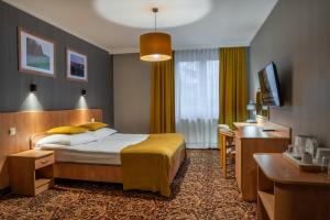 Teresin库兹尼亚纳波莱昂斯卡酒店的配有一张床和一张书桌的酒店客房
